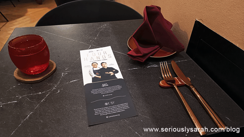 table setting with glass of water menu fork and knife and napkin