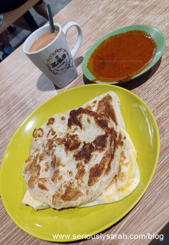 Egg prata and plain prata with fish curry and a cup of milk tea